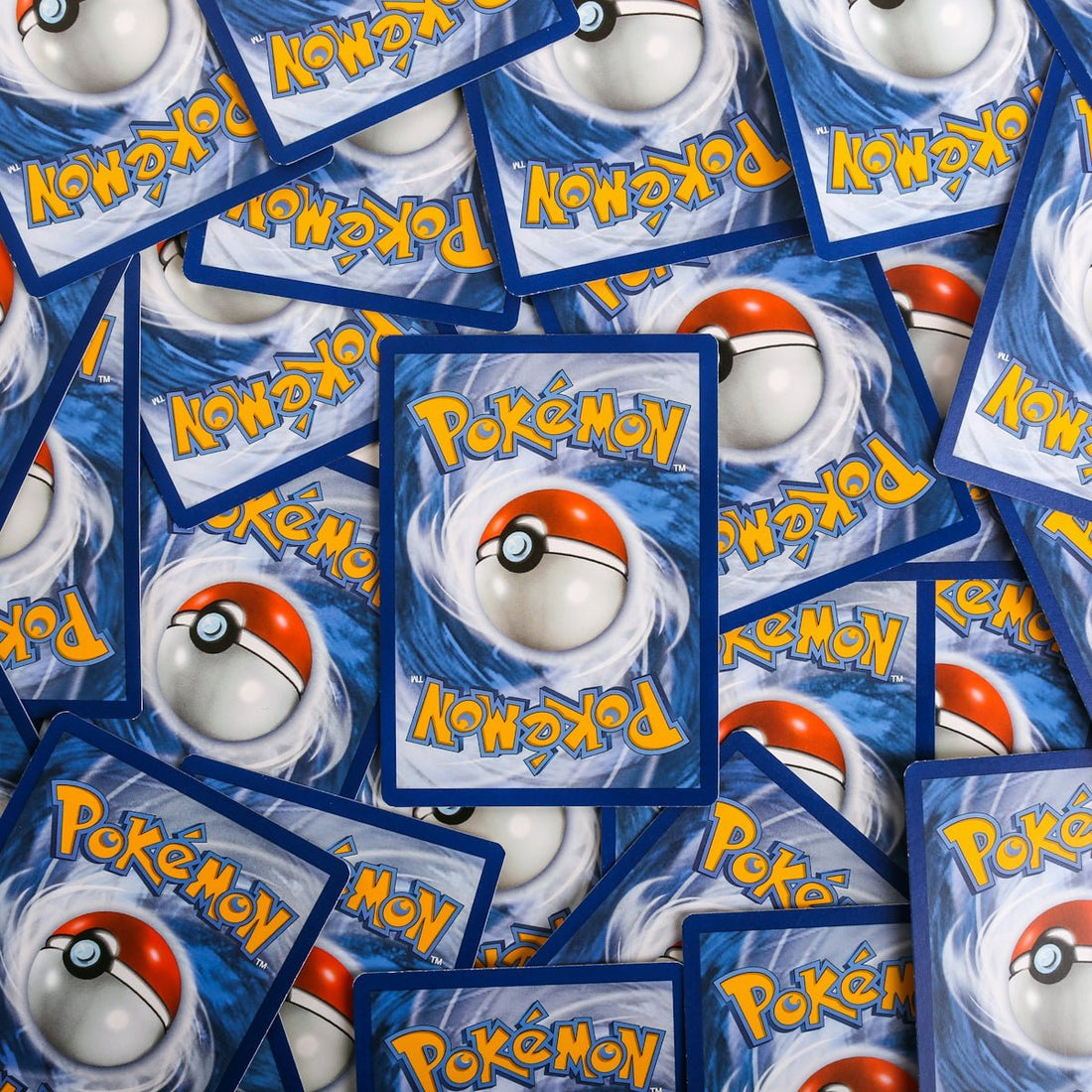 a pile of pokemon trading cards sitting on top of each other